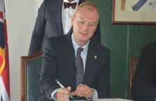 File photo of Governor Augustus Jaspert signing paperwork.
