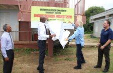 Education Minister Myron Walwyn (left) and Unite BVI  representative Sir Richard Branson unveil Bregado Flax Educational Centre's 'reconstruction project' sign to mark the start of the repairs to teh school.