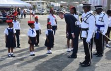Governor Augustus Jaspert shares a smile with this youngster while conducting an inspection of the organisation that participated in Friday's annual staging of the Queen's Birthday Parade.