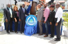 Government officials with the new 'Department of Labour & Workforce Developmen' sign.