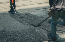 Workers on Asphalting paver machine during Road street repairing works