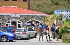 Residents maintain a relatively fair distance between each other as they wait to conduct business with MoneyGram on Flemming Street, Tortola.