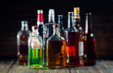 Group of various bottles of alcohol on the wooden bar counter