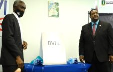 Premier Andrew Fahie (right) and Chairman of the Board of Directors at the BVIPA, Kelvin Hodge poses beside the new logo for the BVIPA.