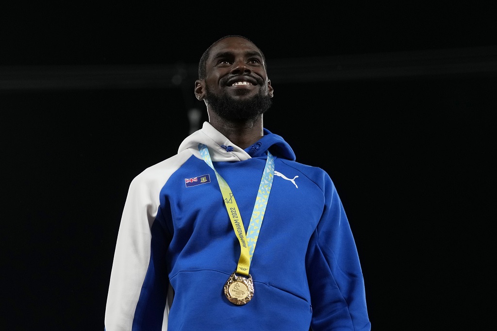Kyron McMaster is all smiles on the podium after striking gold in the Men's 400 meters hurdles event at the Commonwealth Games in Birmingham, England on Saturday, Aug. 6, 2022. (AP Photo/Alastair Grant)