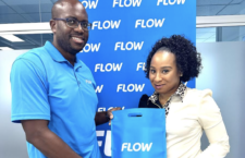 Flow BVI Commercial Manager, Marlon A. Solomon presents Latoya Cotton, the winner of the St. Kitts Music Festival Promotion with her prize. She won a complimentary trip for two, to the festivities.
