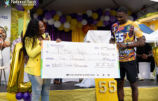 CEO of National Bank of the. Virgin Islands, Joy N. Penn presenting a $5,000 check to D’Moi Hodge.