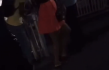 Screenshot from amateur footage of ferry passengers sliding dangerously over the water’s edge in a dimly lit area to get past the closed gate at the Road Town ferry terminal.