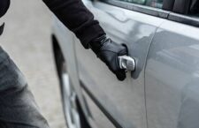 Close up on car thief hand pulling the handle of a car. Car thief, car theft concept